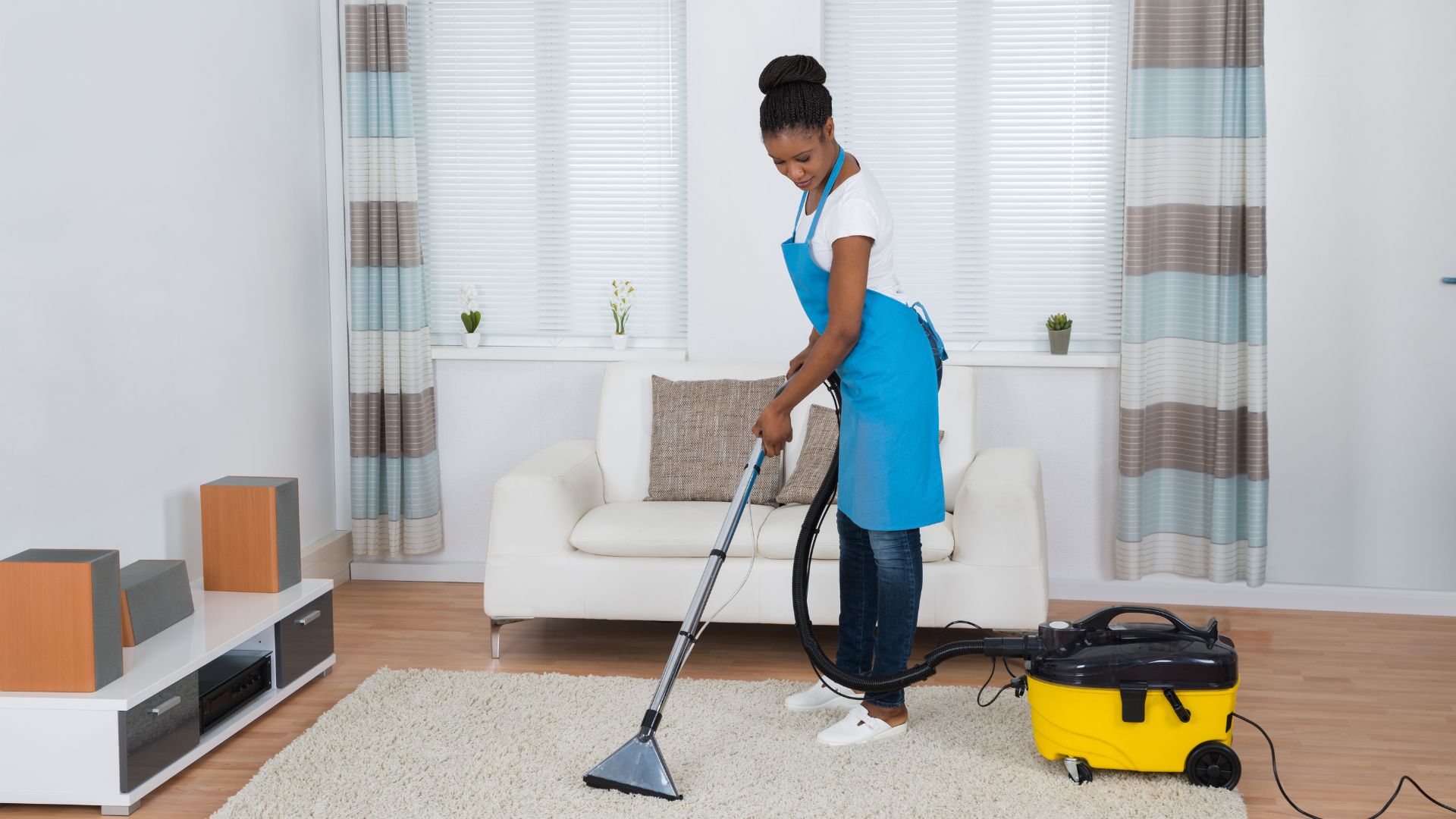 Woman vacuuming carpet in living room