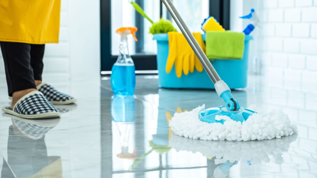 Cleaning supplies and mop on tiled floor.