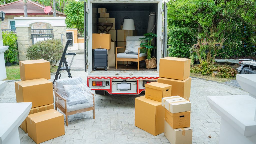 Moving truck with boxes and furniture outdoors
