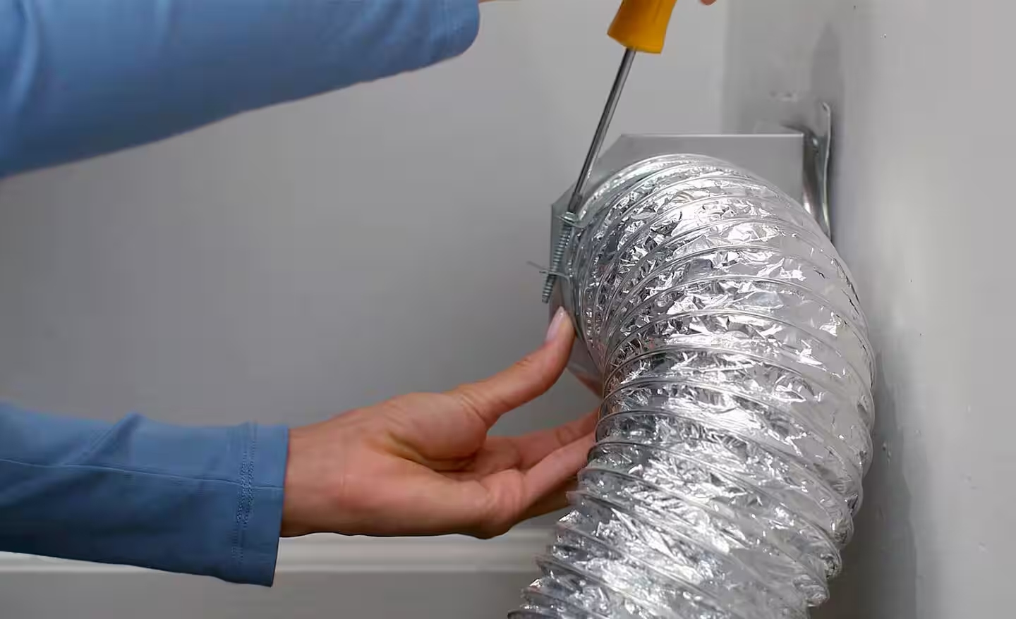 Securing dryer vent with screwdriver and clamp